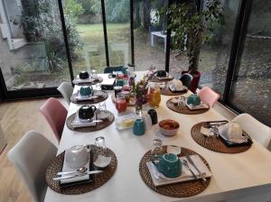 - une table avec des assiettes et des ustensiles dans l'établissement Le Clos de la Commanderie, à Amboise
