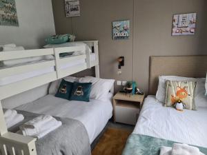 a bedroom with two beds and a bunk bed at Mawgan Pads Mawgan Porth in Mawgan Porth