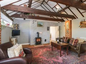 a living room with a couch and a wood stove at Old Cart Shed in Lyneham