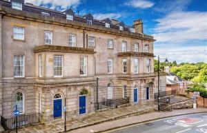 un gran edificio de piedra con puertas azules en una calle en NiCheGetaway, en Shrewsbury