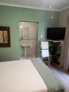 ein Schlafzimmer mit einem Bett und ein Badezimmer mit einem Waschbecken in der Unterkunft Montrose Valley B&B in East London + 18 Fotos