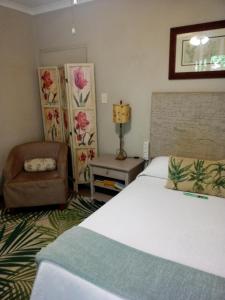 ein Schlafzimmer mit einem großen Bett und einem Stuhl in der Unterkunft Montrose Valley B&B in East London