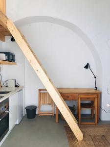 a wooden staircase in a kitchen with a table and a desk at Estudio do Loureiro in Vidigueira