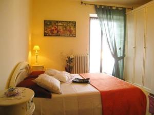 a bedroom with a large bed with a window at Bed and Breakfast Due Leoni in Torri del Benaco