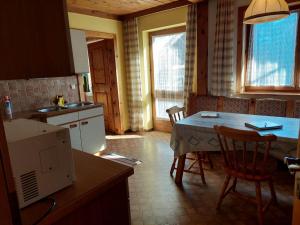 a kitchen with a table and chairs in a kitchen at Ferienwohnung Muhlbauer in Wald im Pinzgau