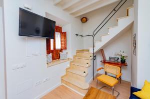 a living room with stairs and a flat screen tv at CASA EL RINCONCITO in Antequera