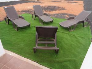 trzy krzesła siedzące na zielonej trawie w obiekcie Casa Ana Perez w mieście Antigua