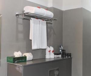 a bathroom with white towels on a shelf at SATRA WAYANAD in Kalpetta