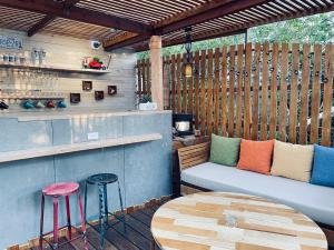 a patio with a bench and a table and stools at Cloud Inn in Hengchun South Gate