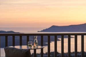 a table with two wine glasses on a balcony at Orama Hotel & Spa in Fira