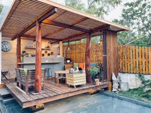 a wooden pergola with a table and a kitchen on a patio at Cloud Inn in Hengchun South Gate