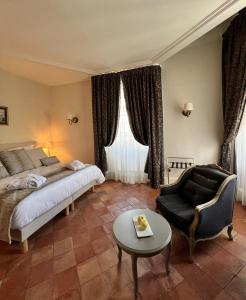 een slaapkamer met een bed, een stoel en een tafel bij Chambres d'hôtes Relais Mira Peis in Mirepoix