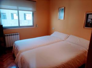 a bedroom with two beds and a window at La Torre in Oviedo