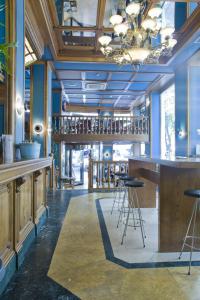 - un bar dans une pièce dotée de murs bleus et de tabourets dans l'établissement II Castillas Madrid, à Madrid