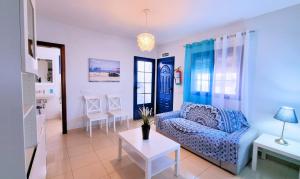 a living room with a blue couch and a table at Chinijo Beach in Caleta de Sebo