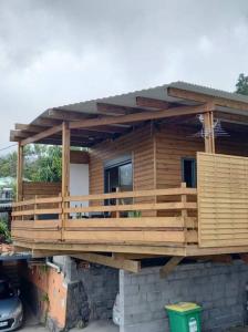 una casa construida con una terraza de madera en Bungalow de la caz l'écho en Cilaos