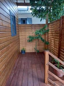 a wooden patio with a tree and a wooden fence at Bungalow de la caz l'écho in Cilaos