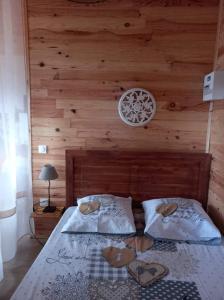 1 dormitorio con 1 cama con pared de madera en Bungalow de la caz l'écho, en Cilaos