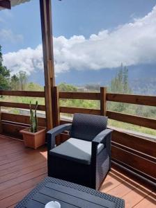 um alpendre com uma cadeira, uma mesa e uma vista. em Bungalow de la caz l'écho em Cilaos