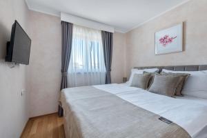 una camera con un grande letto e una TV a schermo piatto di Apartmani Rubinić a Turanj (Torrette)