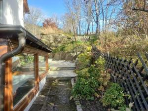 une clôture en bois à côté d'un chemin à côté d'une maison dans l'établissement Black Forest Birdnest, à Schonach