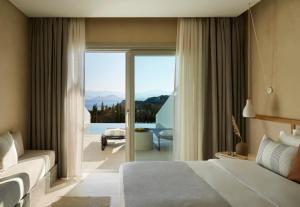 a bedroom with a bed and a view of the ocean at PAROCKS Luxury Hotel & Spa in Ambelas