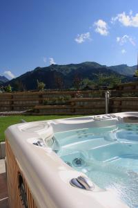 a jacuzzi tub with a view of the mountains at Gasthof Hirschen in Sibratsgfäll