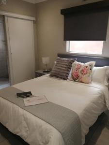 a bedroom with a large white bed with a window at 394OnEmus in Pretoria