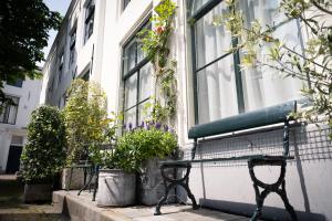 a bench sitting in front of a building with flowers at De Soeten Inval in Middelburg