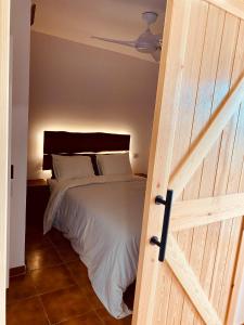 1 dormitorio con 1 cama y puerta de madera en Apartamento Mil Palmeras, en Pilar de la Horadada