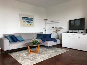 a living room with a couch and a tv at Casa Palmeira - Ferienhaus mit Meerblick in Caniço