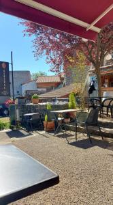 un patio con mesa, sillas, mesa y árbol en Auberge de la Loue, en Vodable