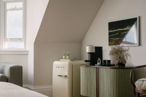 um quarto com um frigorífico e uma mesa em The Dundonald Guesthouse & Cottage em Culross