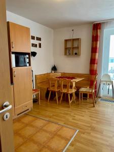 a kitchen and living room with a table and a microwave at Apartmán Riviera J1/1 in Lipno nad Vltavou