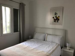 a white bed in a bedroom with a window at Casa Palmeira - Ferienhaus mit Meerblick in Caniço +28 photos