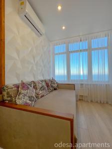 ein Wohnzimmer mit einem Bett und zwei Fenstern in der Unterkunft Sea View Sky 15 Апартаменти в Одесі in Odessa