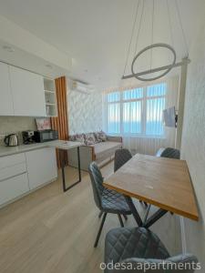 uma cozinha e sala de estar com mesa e cadeiras em Sea View Sky 15 Апартаменти в Одесі em Odessa