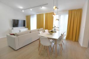 salon z białą kanapą i stołem w obiekcie Residence Family Plazina - Place 1 & 2 w Petrčane