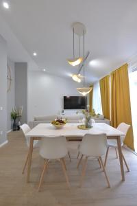 jadalnia z białym stołem i krzesłami w obiekcie Residence Family Plazina - Place 1 & 2 w Petrčane