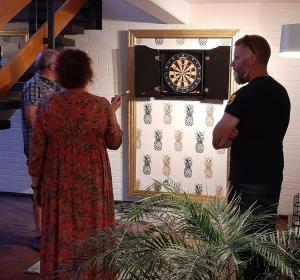 a man and a woman standing next to a dartboard at Breanäs Hotell in Immeln