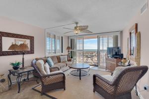 a living room with a couch and chairs and a tv at Gulf Winds 101 in Pensacola Beach