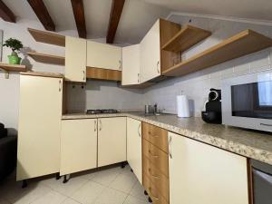 een keuken met witte kasten en een magnetron bij Cà Wanda in Chioggia +2 foto's