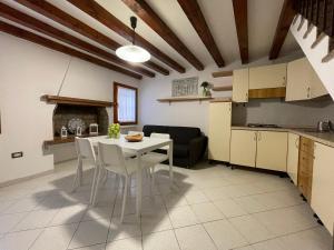 een keuken en woonkamer met een witte tafel en stoelen bij Cà Wanda in Chioggia