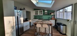 a kitchen with a refrigerator and a table in it at Villa Babeth by Nuits au Port in La Rochelle