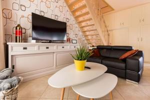 a living room with a white table and a tv at De Notelaar in Alveringem