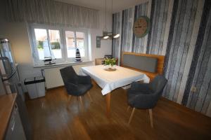 mesa de comedor con sillas y reloj en la pared en Haus Schilling, en Esens