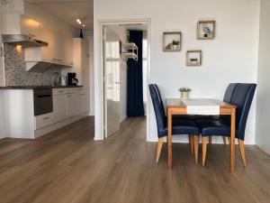 a kitchen and dining room with a table and chairs at Schelp 47 in Zandvoort