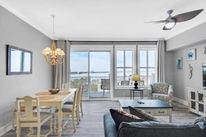 a dining room and living room with a table and chairs at Grand Sandestin 2800 in Destin