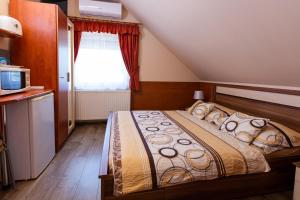 A bed or beds in a room at Erika Vendégház