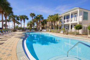 a swimming pool at a resort with palm trees at Destiny Beach Villas #15A in Destin